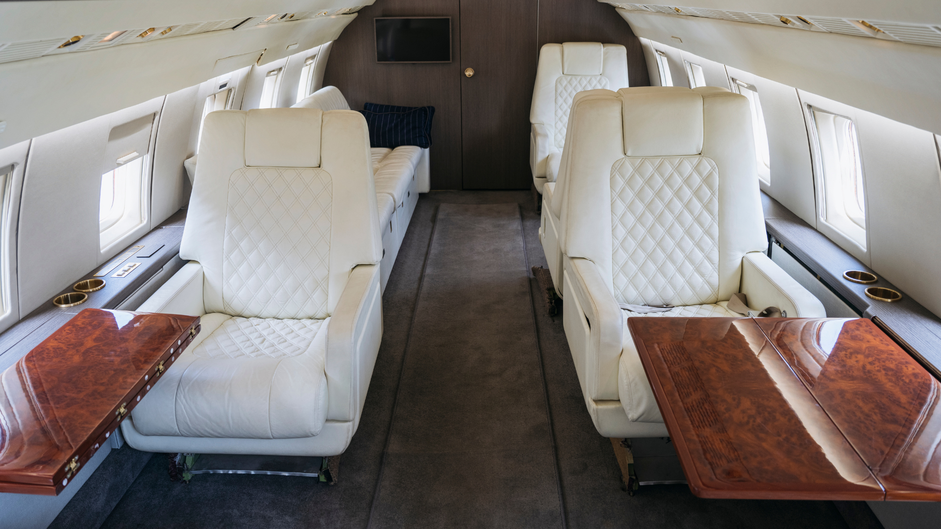 Interior aircraft cleaning - luxury private jet cabin with quilted leather seats and wood trim